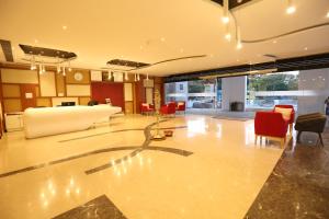 a large lobby with red chairs and a table at Hotel Jump In & Out in Coimbatore