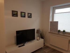 una sala de estar con TV de pantalla plana en un armario blanco en Kleine, ruhige Wohnung in Gelsenkirchen en Gelsenkirchen