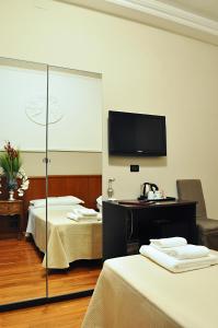 a hotel room with two beds and a flat screen tv at Hotel Twenty Nine in Genova