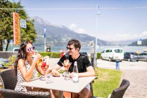 Ein Mann und eine Frau sitzen an einem Tisch in der Unterkunft Garnì Bellavista in Calceranica al Lago