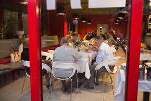 un grupo de personas sentadas en una mesa en un restaurante en Hotel Galaxie, en Zlín