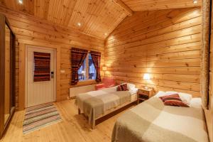 Hotel Uitonniemi في كيميارفي: غرفة نوم بسريرين في كابينة خشب