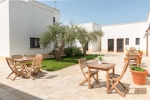 eine Terrasse mit Tischen und Stühlen im Hof in der Unterkunft Tenute D'Onghia in Gioia del Colle