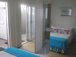 a room with a bed and a glass wall at 20 belladonna avenue Vredehoek Cape town in Vredehoek +13 photos