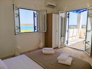 Schlafzimmer mit einem Bett und Meerblick in der Unterkunft SempreViva Sea Houses in Diakofti