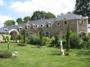una gran casa de piedra con un jardín delante de ella en Le Clos Saint Fiacre, en Carentoir