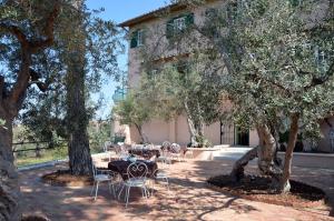 a patio with tables and chairs under trees at Antica Villa di Bruto in Tivoli