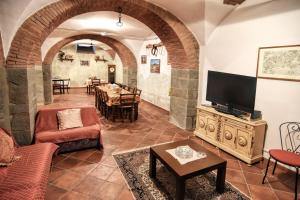salon z kanapą, telewizorem i stołem w obiekcie Villa Il Palazzo w mieście Cortona