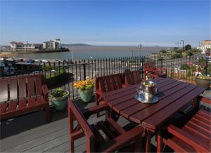 een houten tafel en stoelen op een terras bij New Birchfield Hotel in Weston-super-Mare