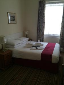 A bed or beds in a room at New Birchfield Hotel