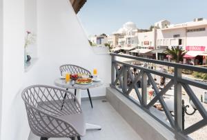 een balkon met een tafel en stoelen en uitzicht op de stad bij Santorini Main Square in Fira