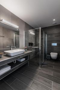 La salle de bains est pourvue d'une baignoire, d'un lavabo et de toilettes. dans l'établissement Santorini Main Square, à Fira