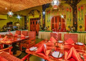 a dining room with a table with red napkins at Ramoji Film City- Tara Comfort Hotel in Pedda Ambarpet