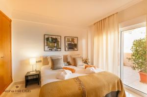 a hotel room with a large bed and a large window at Aloha Hill Club in Marbella