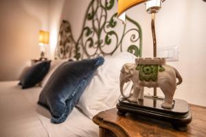 una lampada su un tavolo accanto a un letto di Bellezza Suites a Cagliari