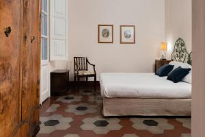 a bedroom with a bed and a chair in it at Bellezza Suites in Cagliari