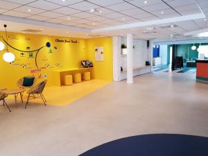 a room with yellow walls and a table and chairs at ibis Styles Marseille Plan de Campagne in Les-Pennes-Mirabeau