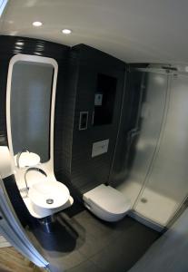a bathroom with a toilet and a sink and a shower at Apartamentos Apolo in Madrid +73 photos