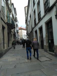 Un par de personas caminando por una calle en Fogar de Breogan, en Santiago de Compostela