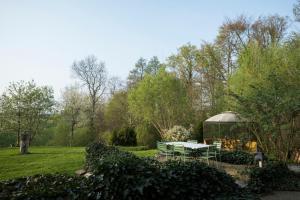 una mesa de picnic y un cenador en el jardín en Bellevue Maison de Greunebennet, en Plombières