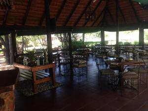an empty restaurant with tables and chairs in at Phokoje Bush Lodge in Selebi-Pikwe