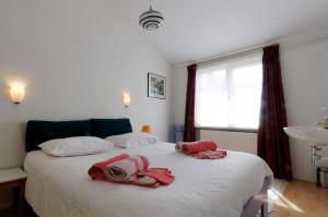 Un dormitorio con una cama blanca con toallas. en holiday cottage 'FLOW', en Bergen