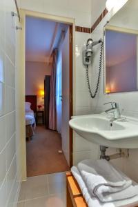 uma casa de banho com um lavatório e um espelho em Le Home em Vincennes