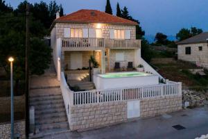 a house with a swimming pool in front of it at Holiday Home Vallis in Povlja