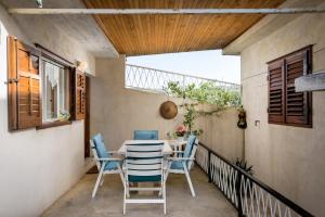 een terras met een tafel en stoelen op een balkon bij Holiday Home Vallis in Povlja