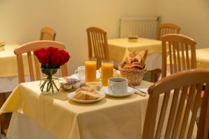 ein Tisch mit Brot, Orangensaft und Blumen darauf in der Unterkunft Le Home in Vincennes