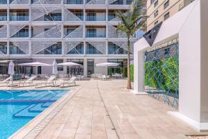 een buitenzwembad met stoelen en een gebouw bij Nyota Hotel & Conference Center in Mamaia