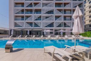 a swimming pool with chairs and a building at Nyota Hotel & Conference Center in Mamaia