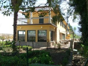 a yellow house with a balcony on top of it at Hotel O Casino da Rasa in Nogueira de Ramuin