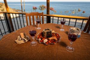 una mesa con copas de vino y un plato de comida en Beach View, en Kalí Limenes