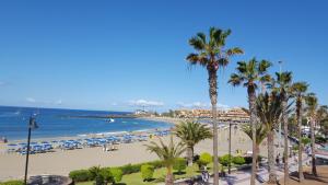 a view of a beach with palm trees and the ocean at Torres del Sol Playa de Las Vistas FREE WIFI in Playa de las Americas