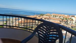 a chair on a balcony with a view of the beach at Torres del Sol Playa de Las Vistas FREE WIFI in Playa de las Americas