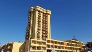 a tall yellow building with many balconies on it at Torres del Sol Playa de Las Vistas FREE WIFI in Playa de las Americas