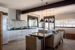 a kitchen with white cabinets and a table with chairs at Villa Manzanilla, Malaga in Alhaurín de la Torre