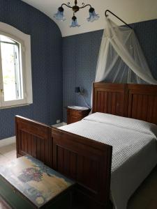 1 dormitorio con cama con dosel y ventana en B&B La Salamandra Kitchengarden, en Isquia