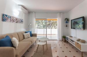 un soggiorno con divano e tavolo di Lets Holidays Castelldefels Diagonal Orient a Castelldefels