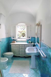 baño con lavabo y aseo y ventana en B&B La Salamandra Kitchengarden, en Isquia