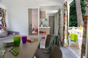 a kitchen and dining room with a table and chairs at Camping Officiel Siblu Le Lac des Rêves in Lattes