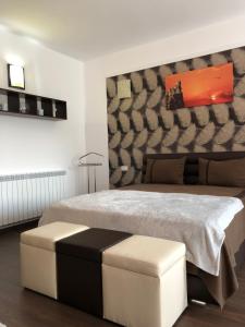 Un dormitorio con una cama grande con un cuadro en la pared. en Vlaicu Apartments, en Constanţa