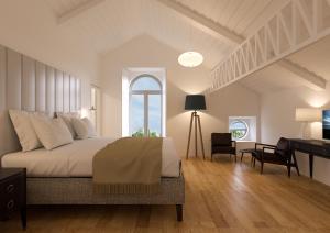 a bedroom with a bed and a desk and a window at Herdade do Ananás in Ponta Delgada
