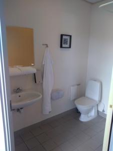 een witte badkamer met een toilet en een wastafel bij Motel Lyren in Padborg