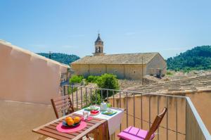 a balcony with a table and chairs and a church at Casa Vella (Vall Petit) in Mancor del Valle