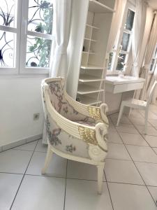 a white chair in a room with a window at Kramwinkelsuite Regensburg in Regensburg