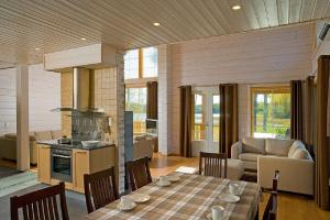 a kitchen and living room with a table and chairs at Saimaa Lakeside in Ruokolahti