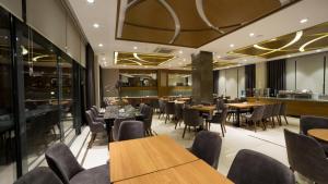 comedor con mesas y sillas de madera en MD Barbaros Hotel en Çanakkale
