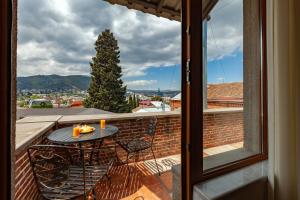 a patio with a table and chairs on a balcony at Penthouse Hotel in Tbilisi City